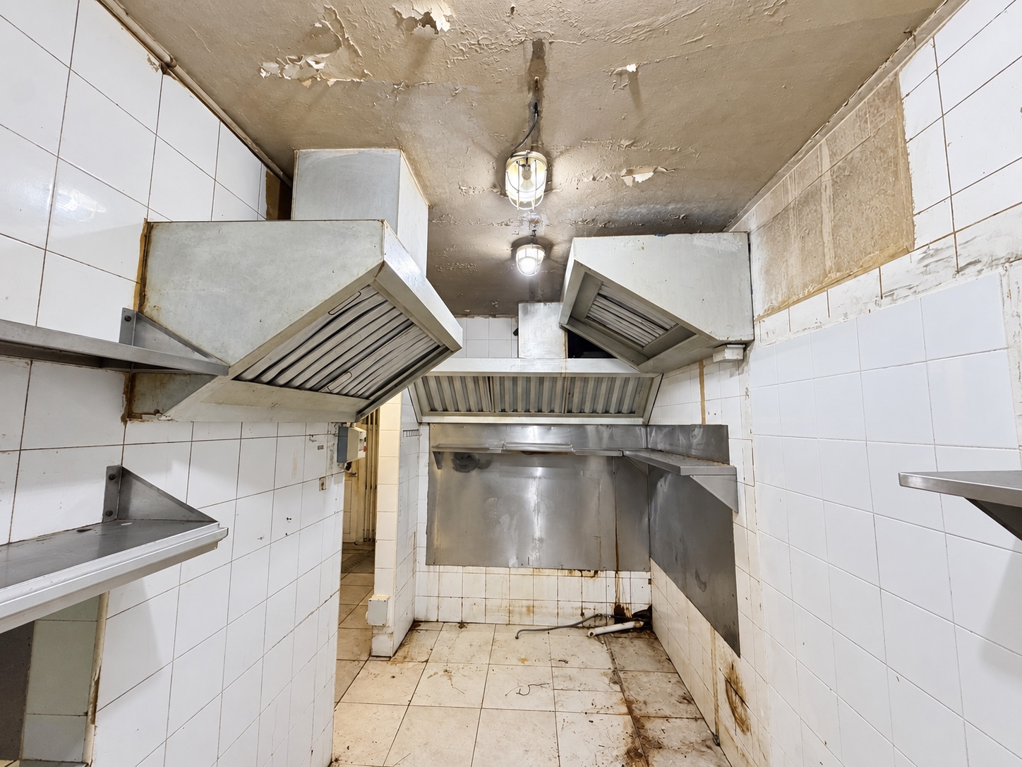 Current kitchen cooking area showing extraction hoods