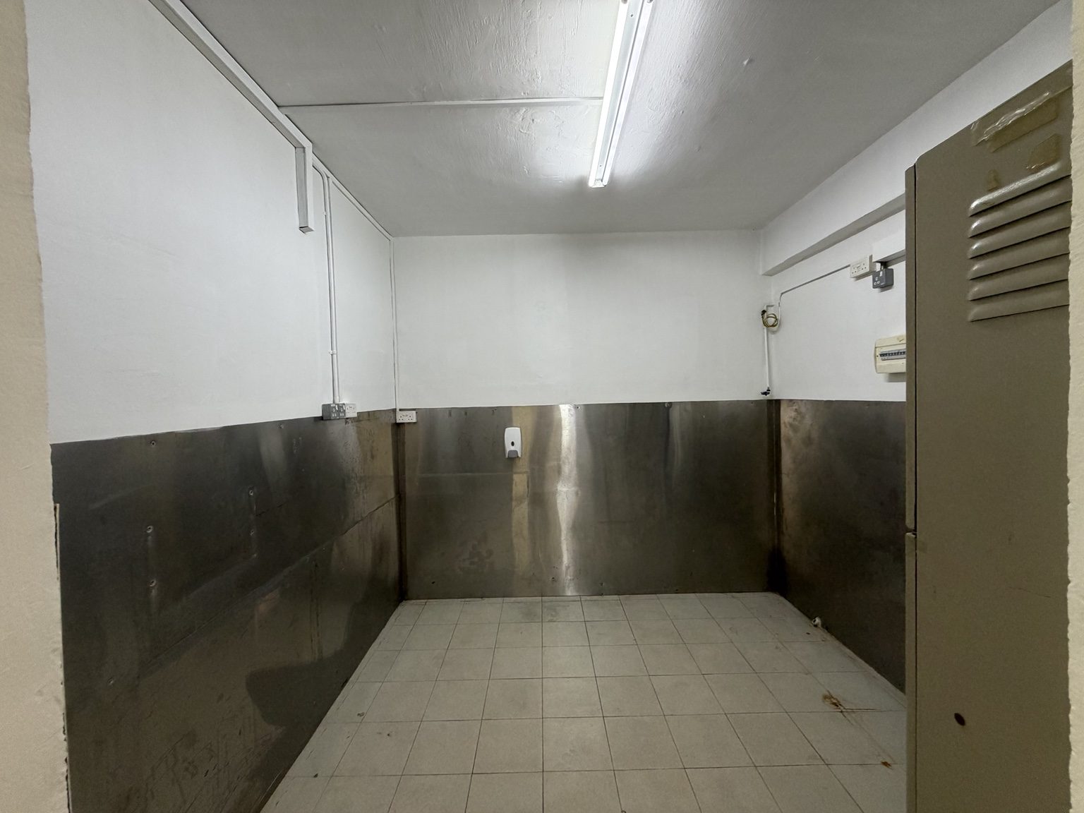 Separate tiled back room with stainless-steel wall panels