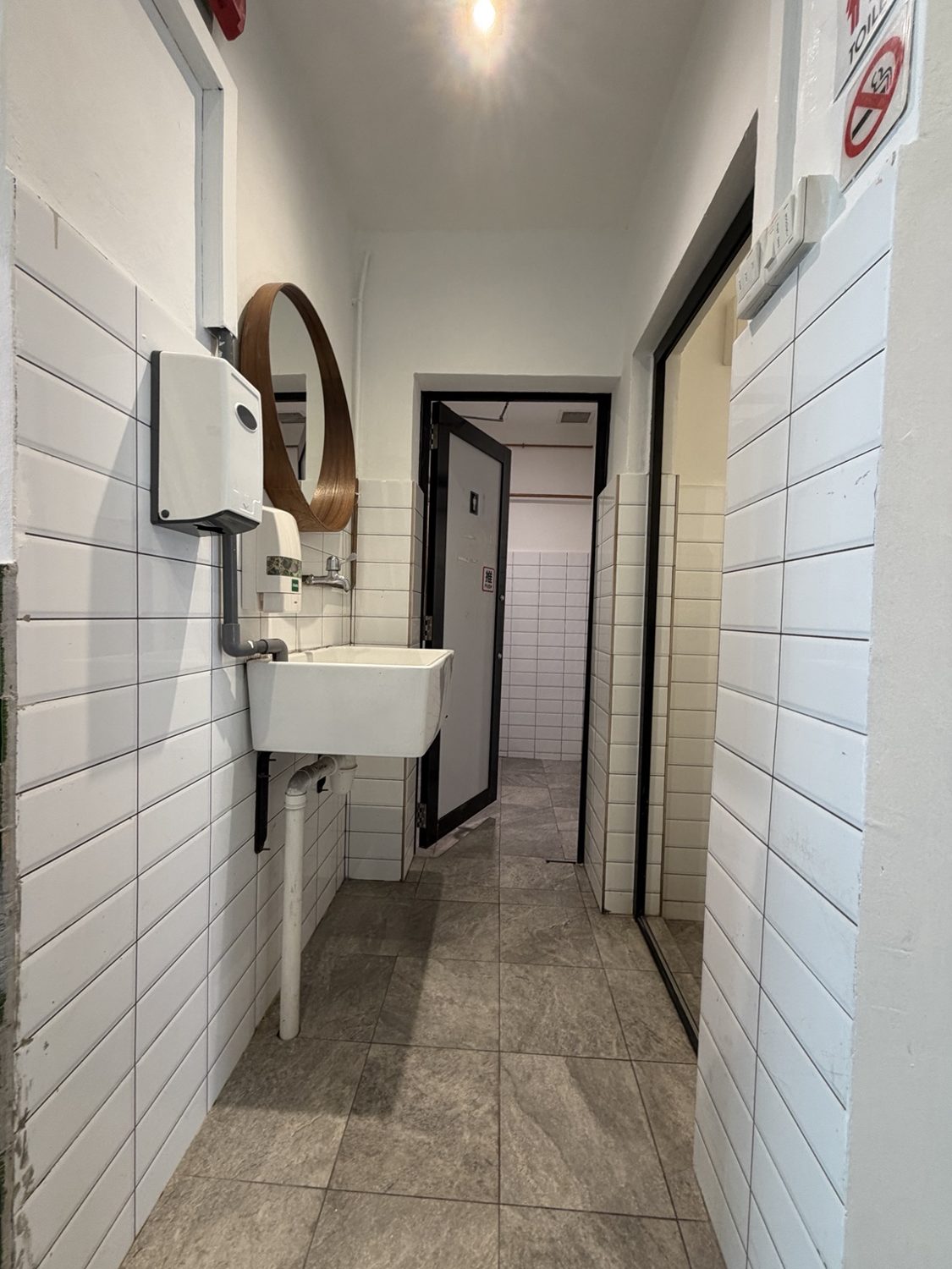 Tiled washroom passage with hand basin